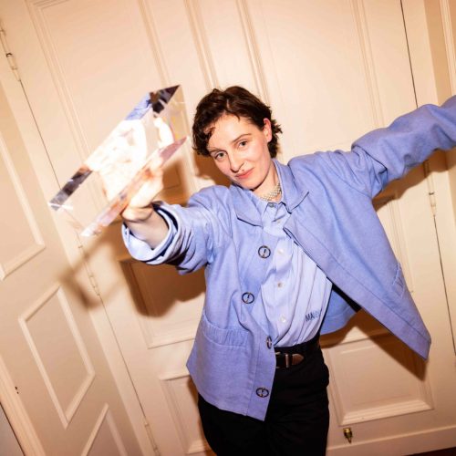 Gewinnerin mit Preis am Türrahmen